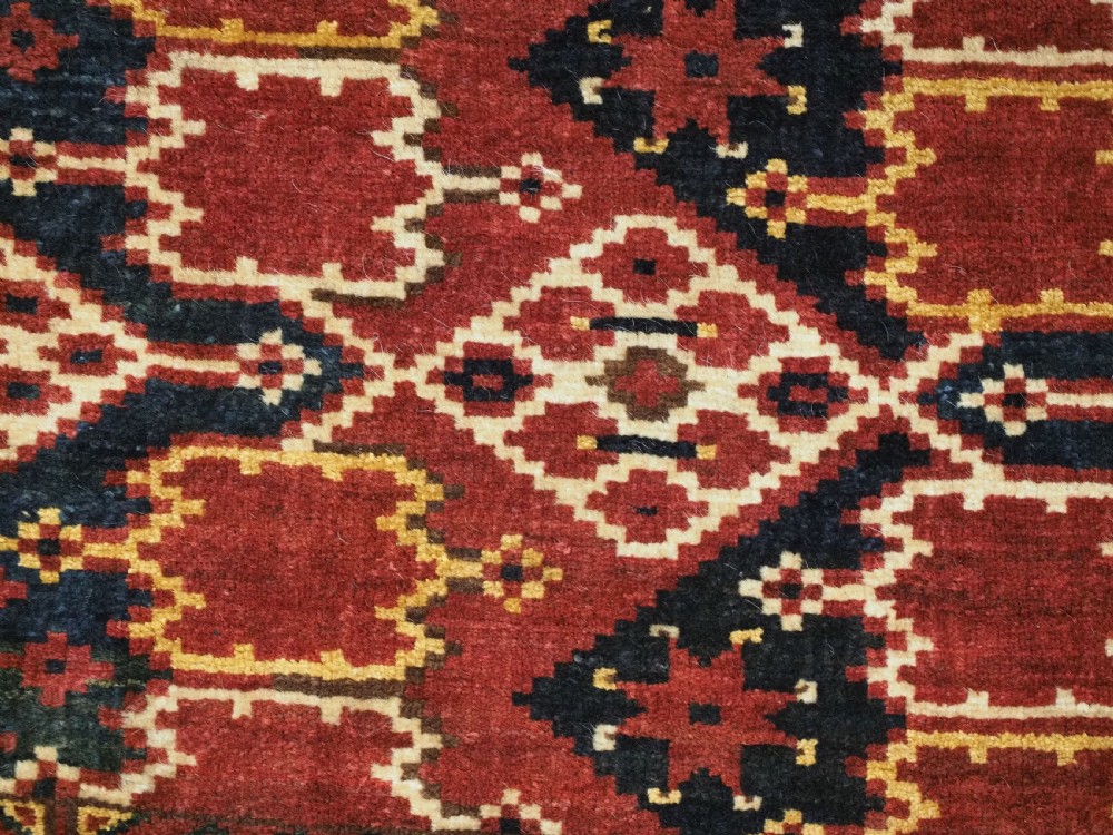 A horizontal rectangular antique Ersari Beshir Turkmen torba textile woven in deep red wool with geometric ikat diamond patterns. View VIII