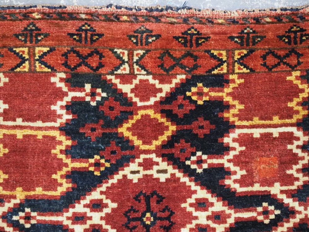 A horizontal rectangular antique Ersari Beshir Turkmen torba textile woven in deep red wool with geometric ikat diamond patterns. View IX