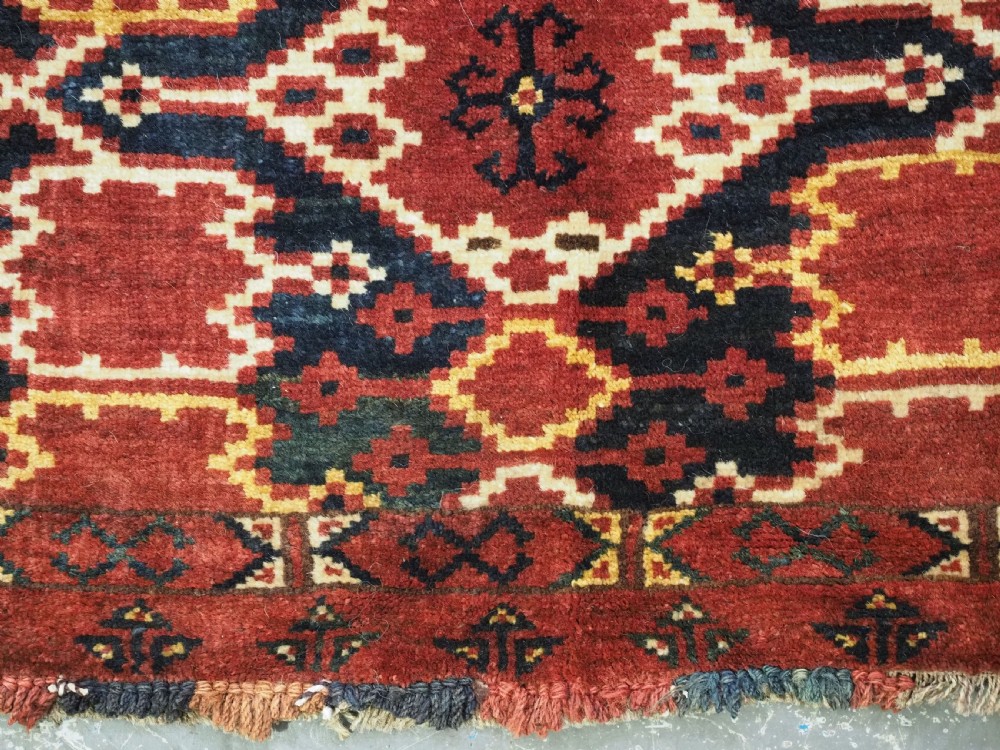 A horizontal rectangular antique Ersari Beshir Turkmen torba textile woven in deep red wool with geometric ikat diamond patterns. View X