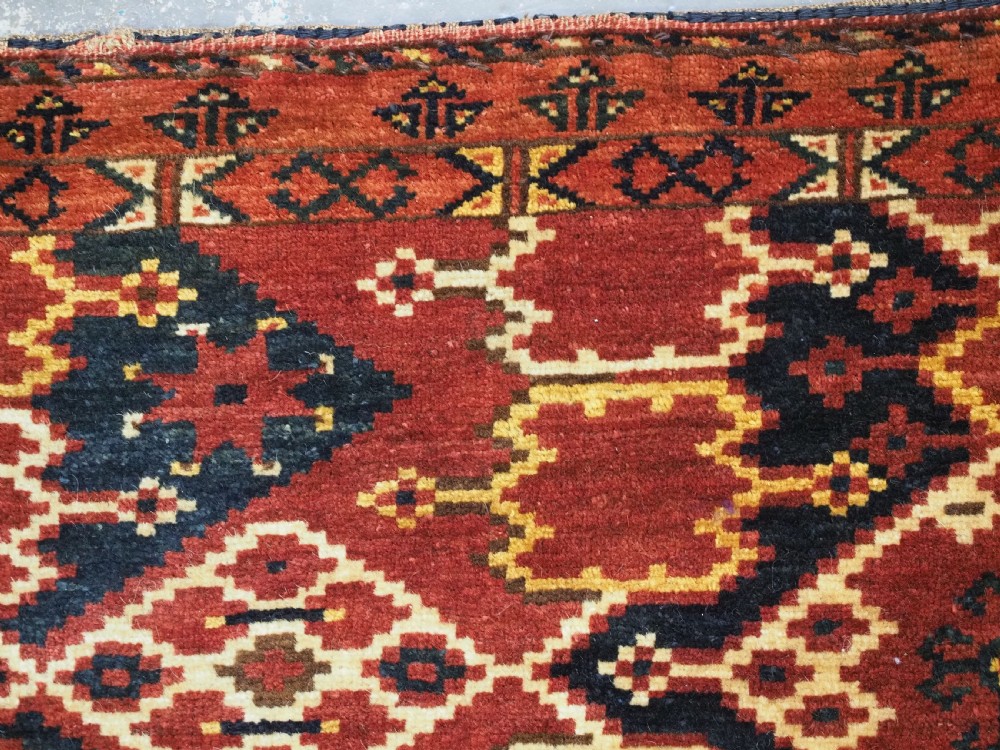 A horizontal rectangular antique Ersari Beshir Turkmen torba textile woven in deep red wool with geometric ikat diamond patterns. View XI