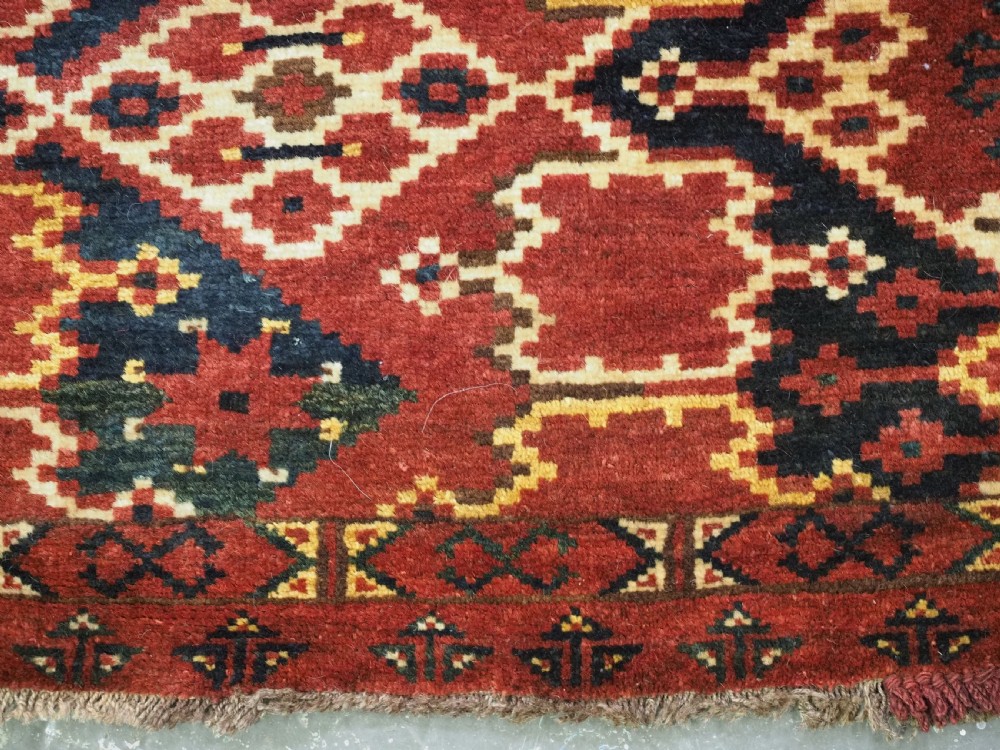 A horizontal rectangular antique Ersari Beshir Turkmen torba textile woven in deep red wool with geometric ikat diamond patterns. View XII