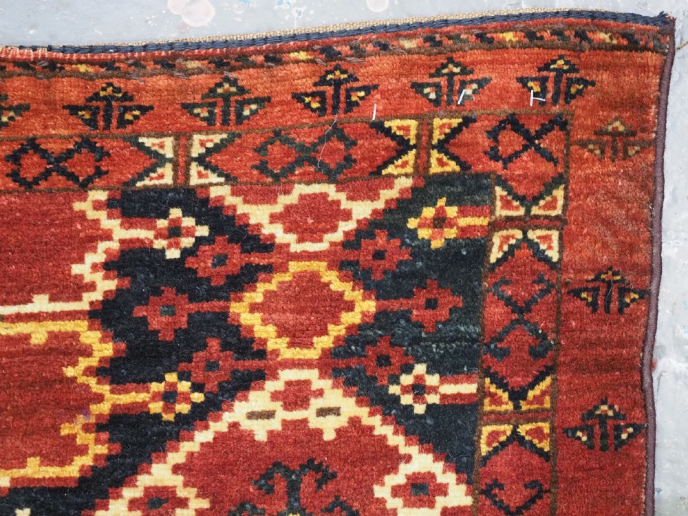 A horizontal rectangular antique Ersari Beshir Turkmen torba textile woven in deep red wool with geometric ikat diamond patterns. View XIII