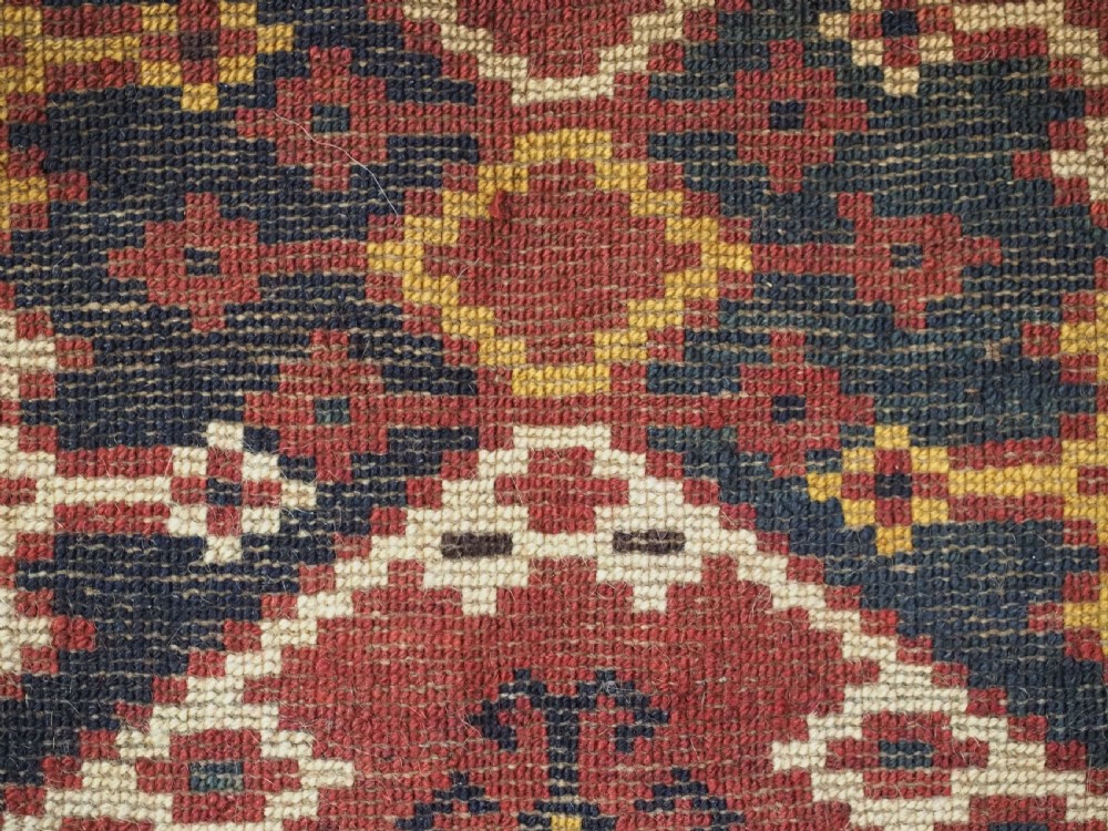 A horizontal rectangular antique Ersari Beshir Turkmen torba textile woven in deep red wool with geometric ikat diamond patterns. View XV