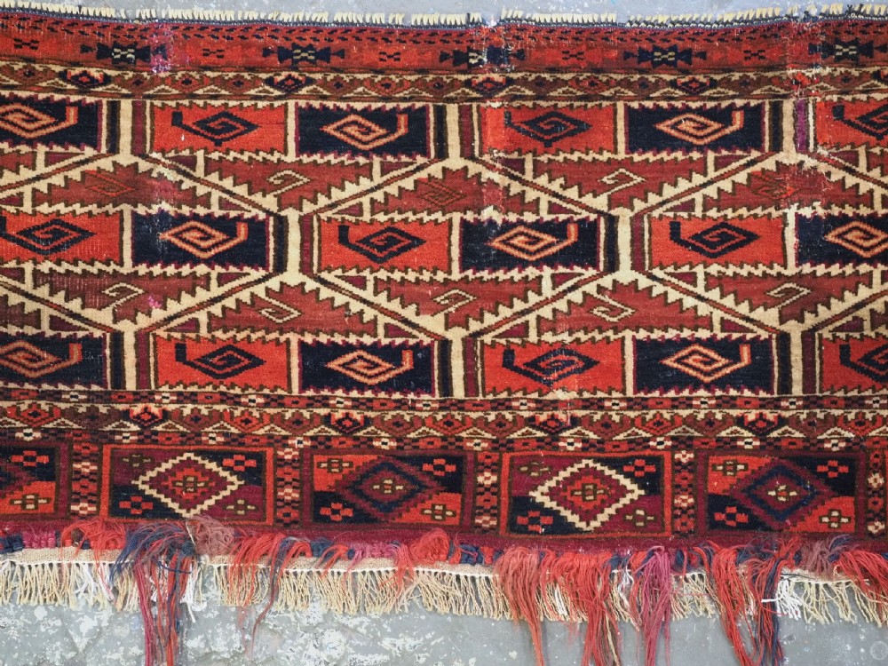 A rectangular hand-woven Tekke Turkmen torba panel featuring deep red, navy blue, and ivory geometric patterns with lower wool fringing. View III