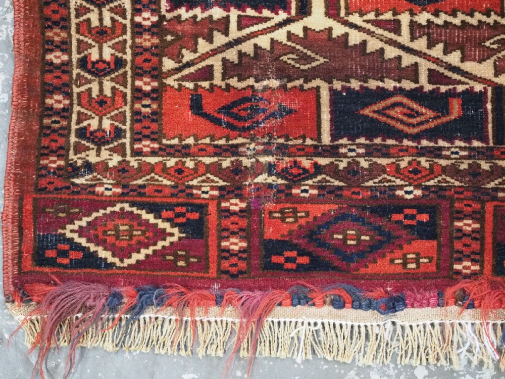 A rectangular hand-woven Tekke Turkmen torba panel featuring deep red, navy blue, and ivory geometric patterns with lower wool fringing. View VI