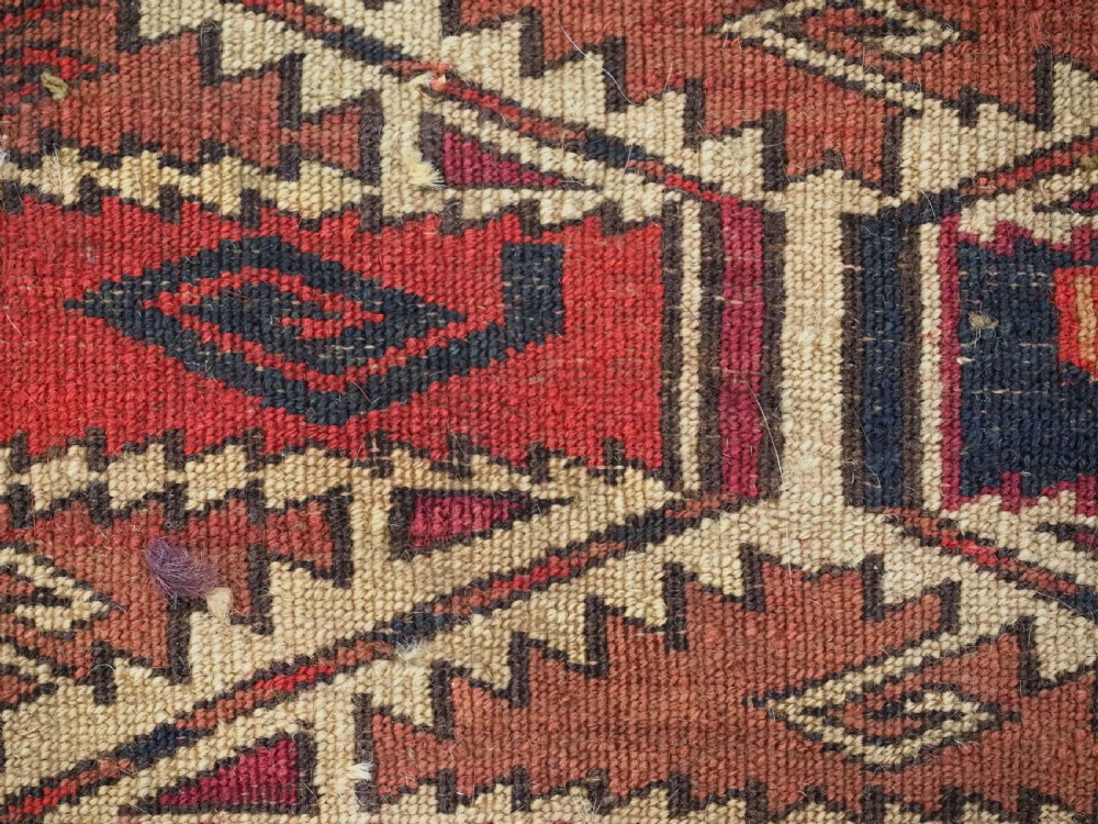 A rectangular hand-woven Tekke Turkmen torba panel featuring deep red, navy blue, and ivory geometric patterns with lower wool fringing. View IX