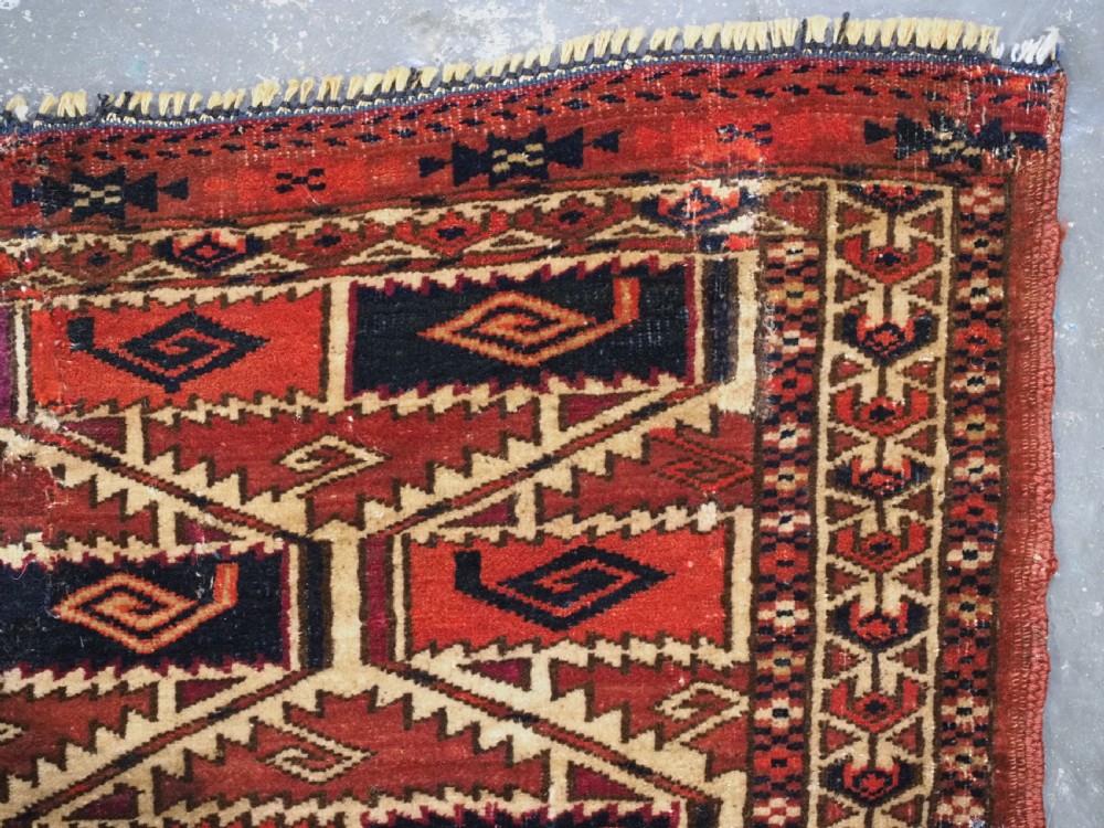 A rectangular hand-woven Tekke Turkmen torba panel featuring deep red, navy blue, and ivory geometric patterns with lower wool fringing. View XII