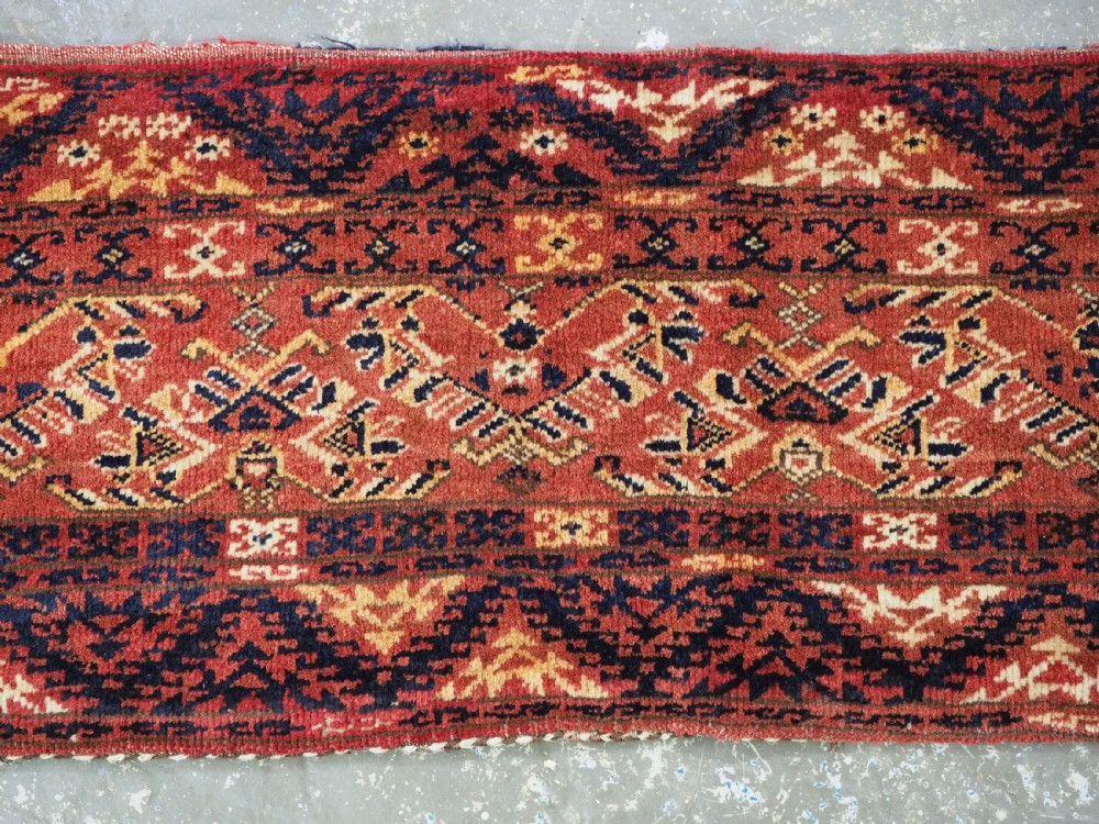 A long horizontal antique Ersari Turkmen wool woven bag face featuring intricate geometric tribal patterns in dark red, navy blue, yellow, and cream tones. View III