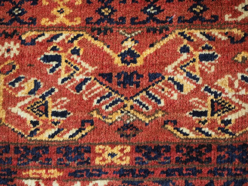 A long horizontal antique Ersari Turkmen wool woven bag face featuring intricate geometric tribal patterns in dark red, navy blue, yellow, and cream tones. View VI