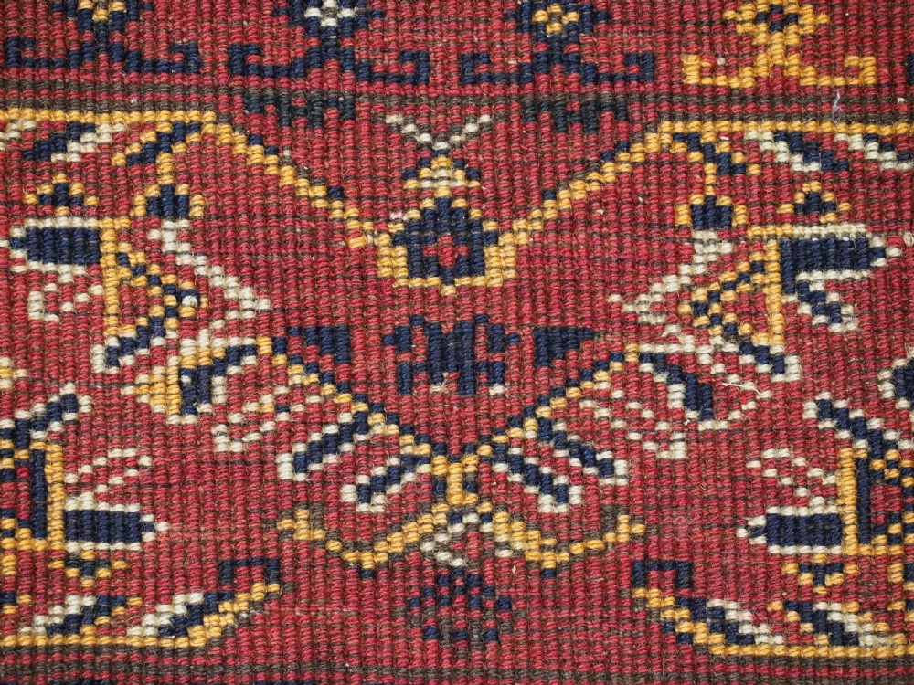 A long horizontal antique Ersari Turkmen wool woven bag face featuring intricate geometric tribal patterns in dark red, navy blue, yellow, and cream tones. View IX