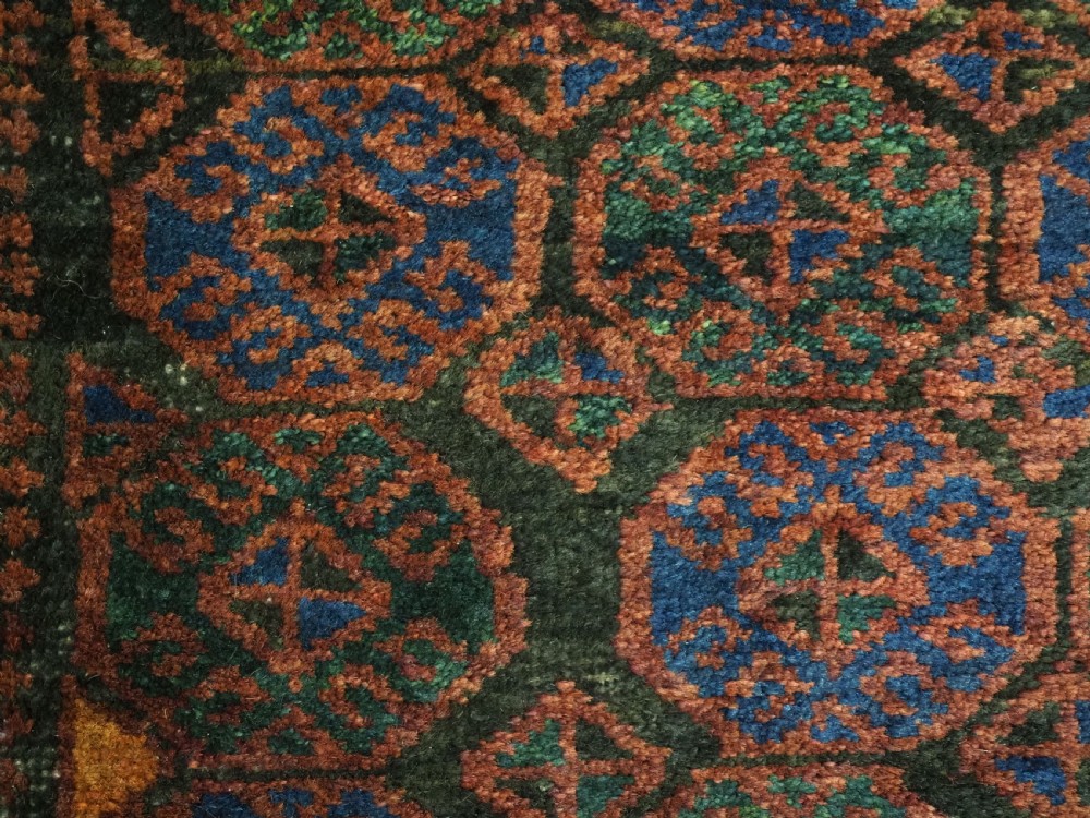 An antique woven Baluch Balisht storage bag featuring dark red and navy blue geometric octagonal motifs with a flat-weave top border and fringed edges. View VI