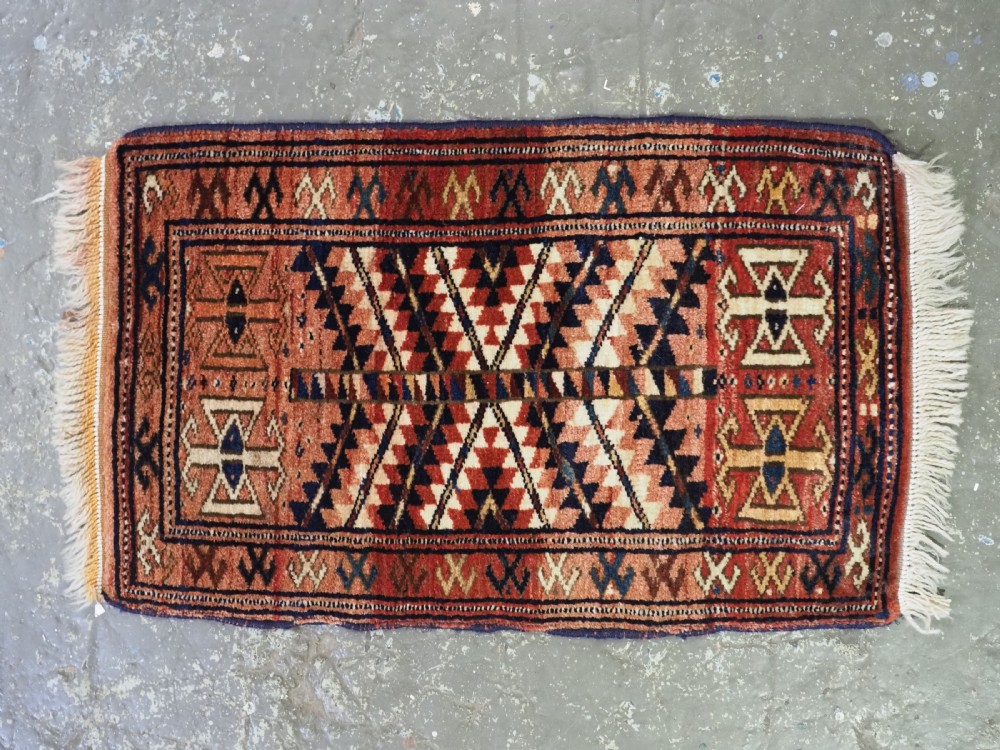 An antique hand-knotted Yomut Turkmen woven bag face featuring intricate geometric serrated motifs in terracotta, navy, and cream with fringed borders. View II