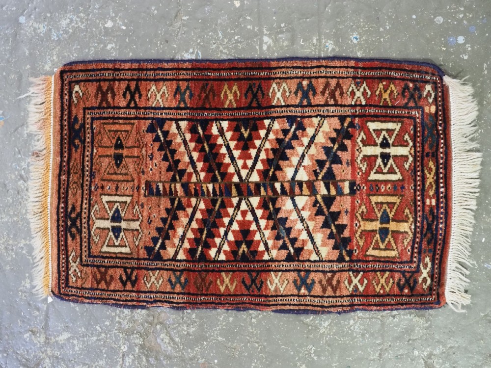 An antique hand-knotted Yomut Turkmen woven bag face featuring intricate geometric serrated motifs in terracotta, navy, and cream with fringed borders. View III
