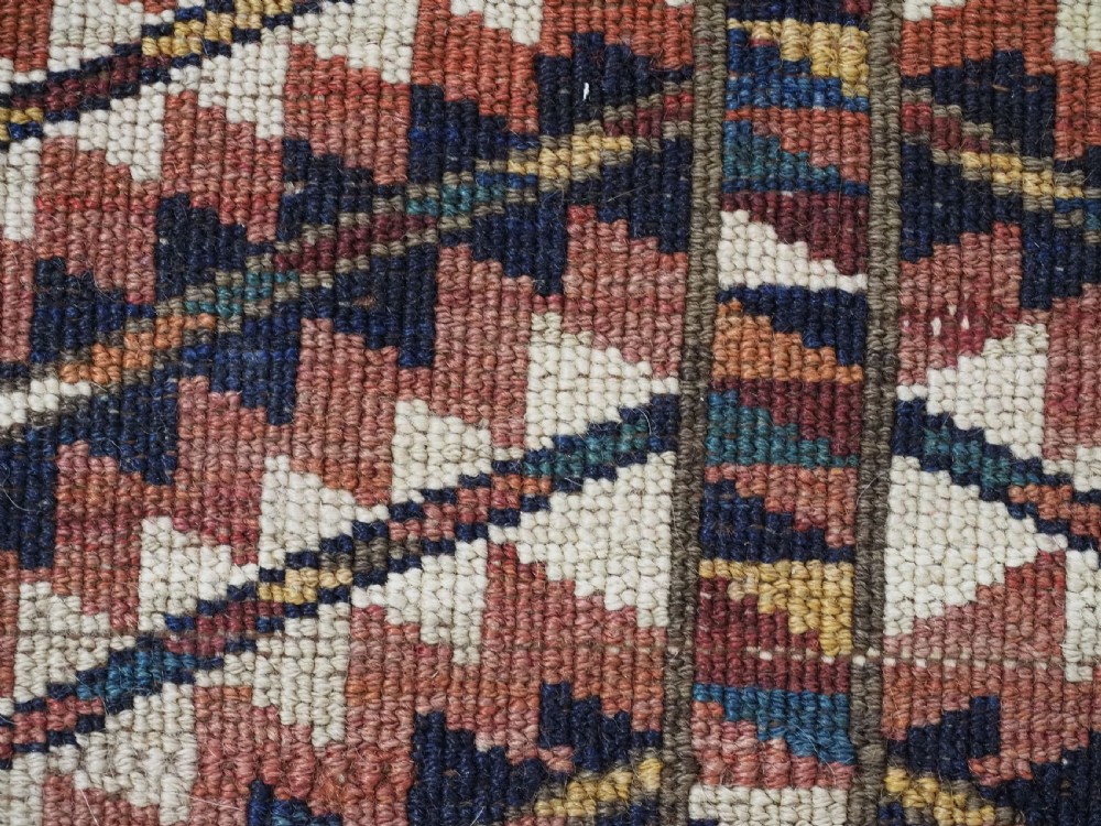An antique hand-knotted Yomut Turkmen woven bag face featuring intricate geometric serrated motifs in terracotta, navy, and cream with fringed borders. View VII