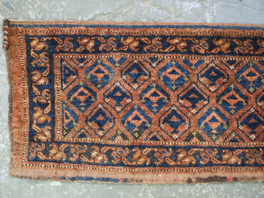 A horizontal antique Ersari Turkmen hand-knotted wool torba face featuring repeated geometric schemle gul motifs in dark blue and terracotta red tones. View II