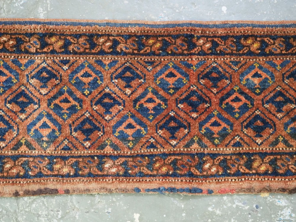 A horizontal antique Ersari Turkmen hand-knotted wool torba face featuring repeated geometric schemle gul motifs in dark blue and terracotta red tones. View III