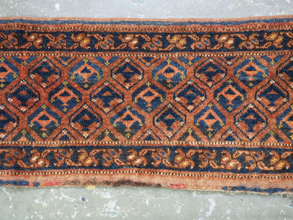 A horizontal antique Ersari Turkmen hand-knotted wool torba face featuring repeated geometric schemle gul motifs in dark blue and terracotta red tones. View IV