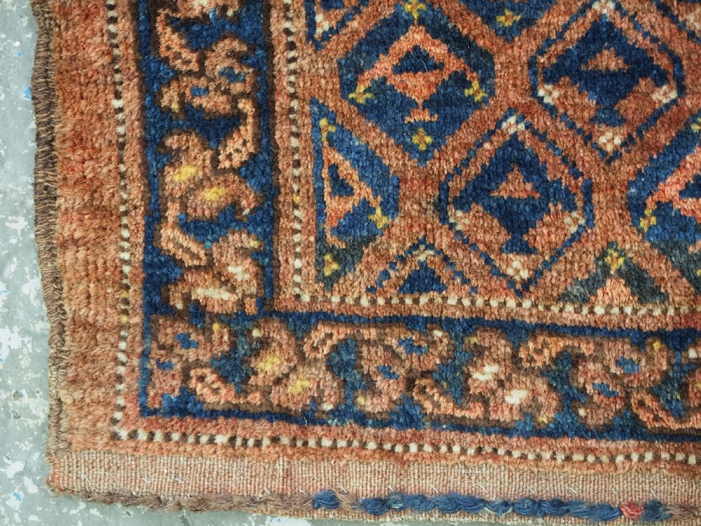 A horizontal antique Ersari Turkmen hand-knotted wool torba face featuring repeated geometric schemle gul motifs in dark blue and terracotta red tones. View VII