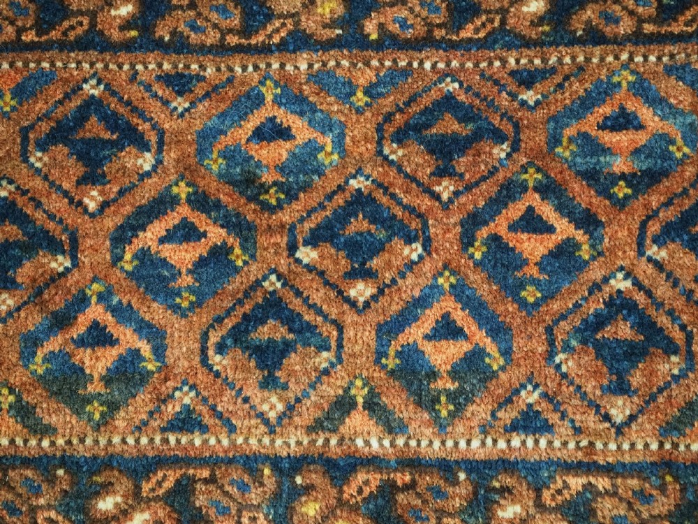 A horizontal antique Ersari Turkmen hand-knotted wool torba face featuring repeated geometric schemle gul motifs in dark blue and terracotta red tones. View IX