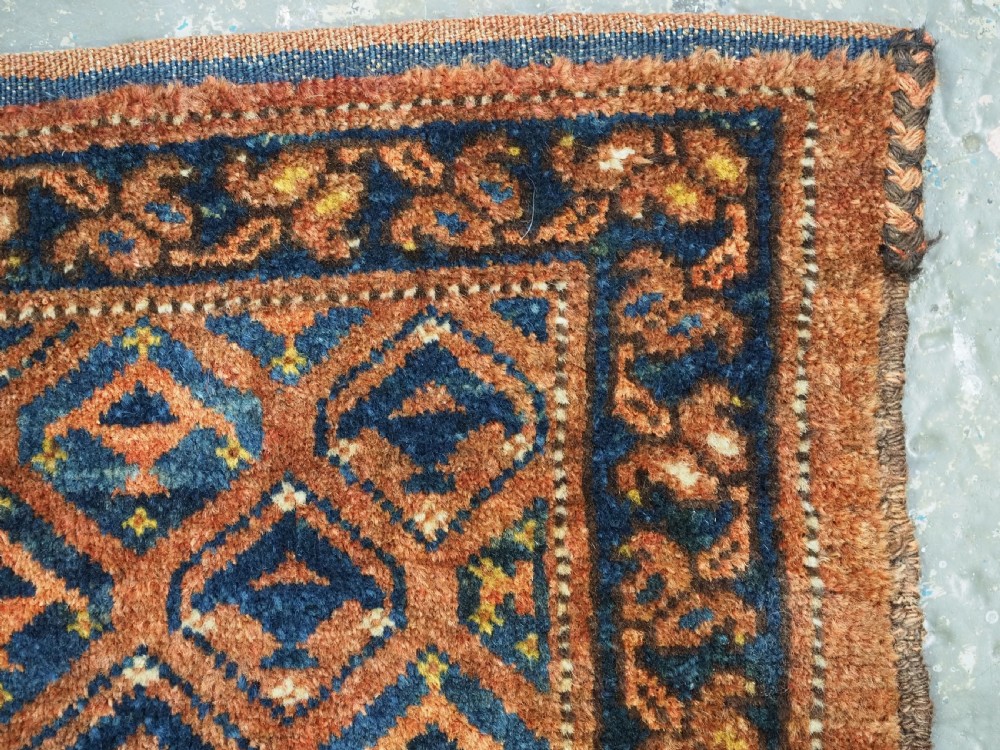 A horizontal antique Ersari Turkmen hand-knotted wool torba face featuring repeated geometric schemle gul motifs in dark blue and terracotta red tones. View X