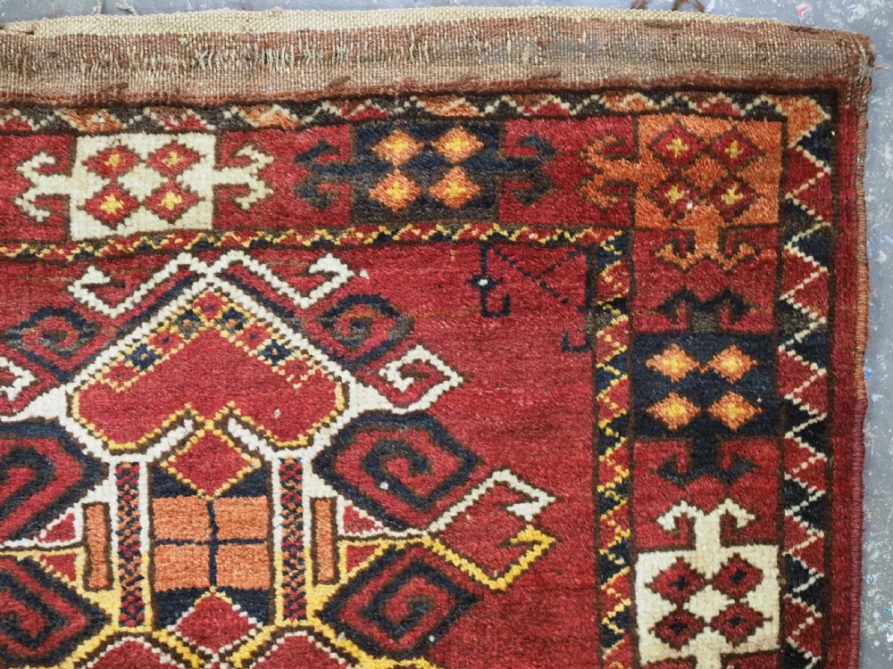 A hand-knotted wool Ersari Turkmen storage bag face featuring a central geometric medallion framed by intricate decorative borders in red, navy blue, yellow, and cream. View III