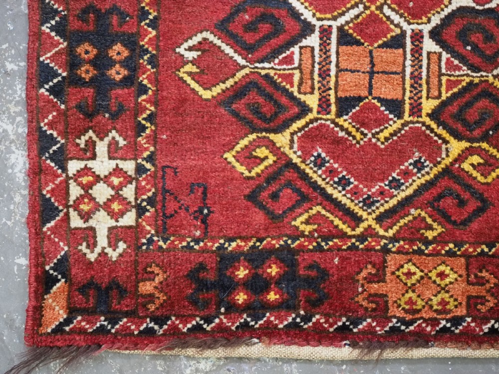 A hand-knotted wool Ersari Turkmen storage bag face featuring a central geometric medallion framed by intricate decorative borders in red, navy blue, yellow, and cream. View IV