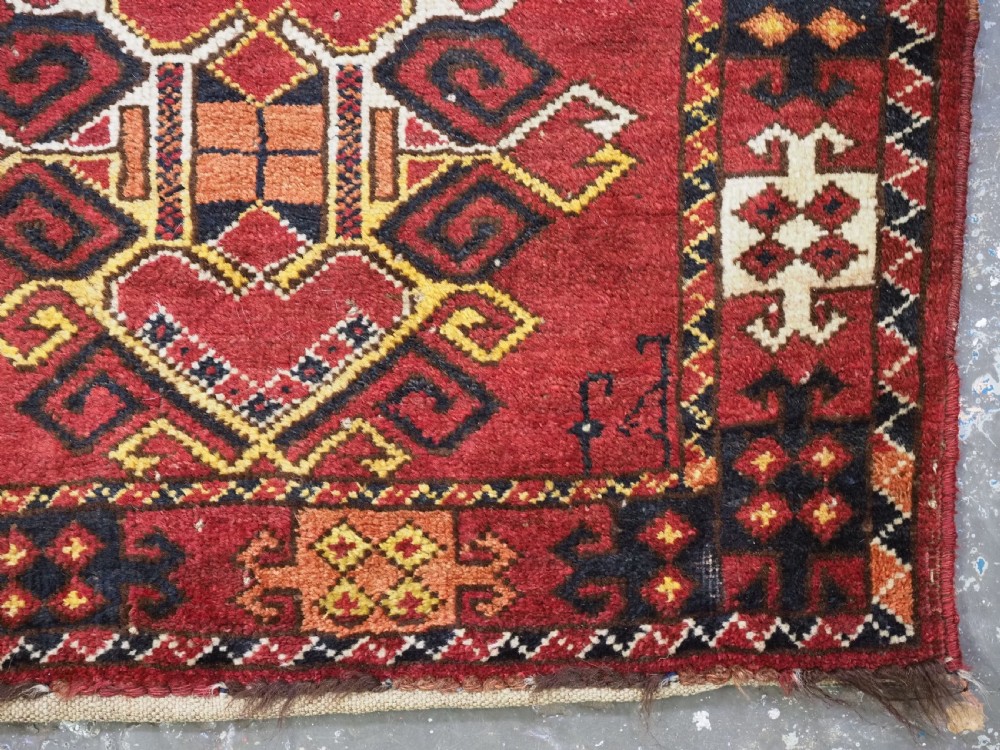 A hand-knotted wool Ersari Turkmen storage bag face featuring a central geometric medallion framed by intricate decorative borders in red, navy blue, yellow, and cream. View VI