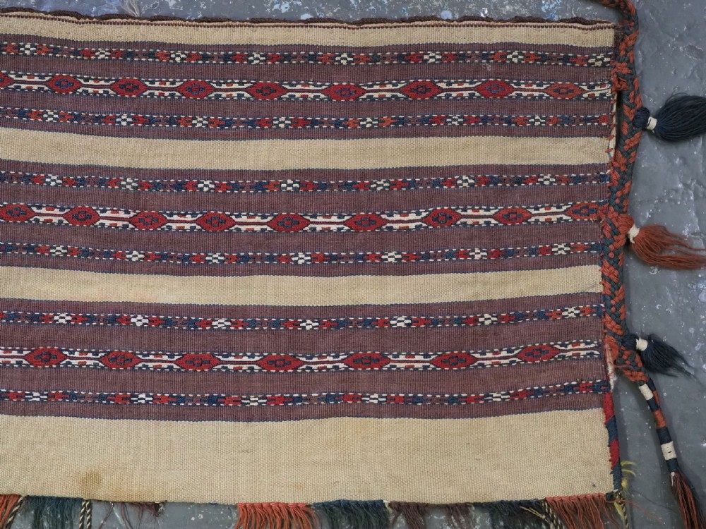An antique Turkmen flatweave panel with horizontal cream, dark brown, and terracotta geometric bands decorated with side tassels and fringing. View III