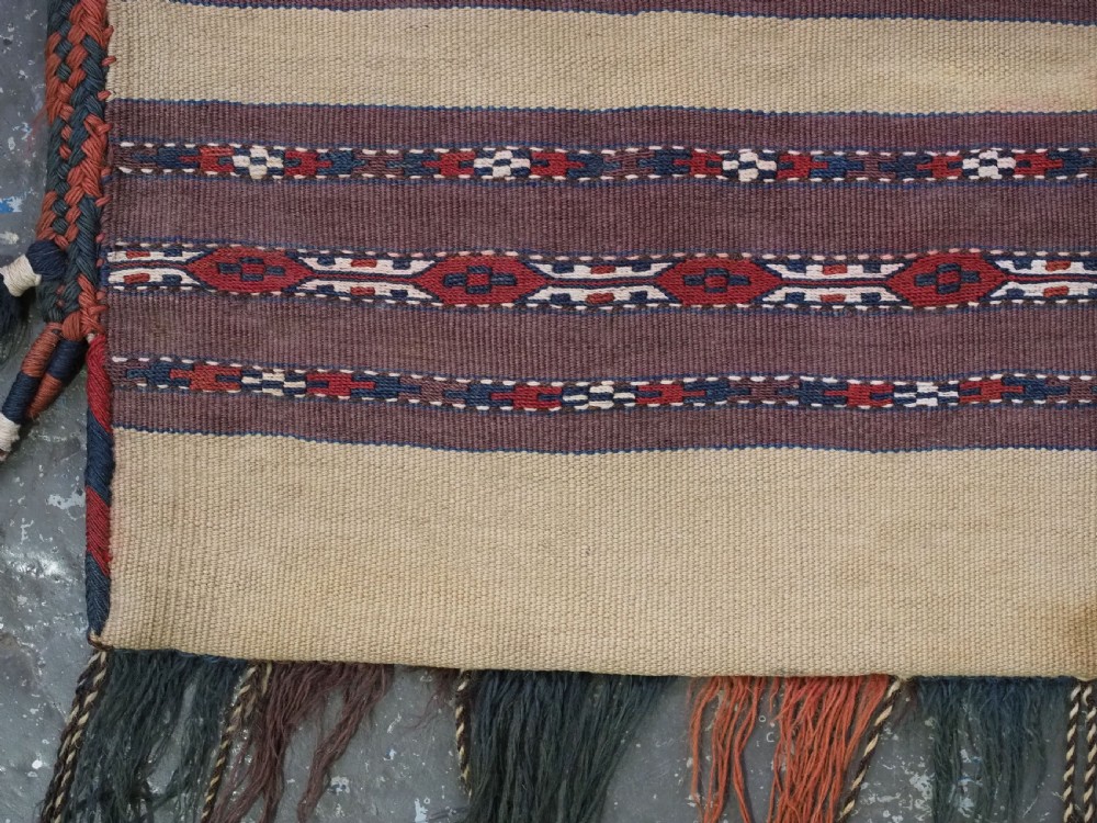 An antique Turkmen flatweave panel with horizontal cream, dark brown, and terracotta geometric bands decorated with side tassels and fringing. View V
