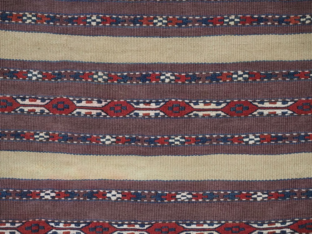 An antique Turkmen flatweave panel with horizontal cream, dark brown, and terracotta geometric bands decorated with side tassels and fringing. View VI