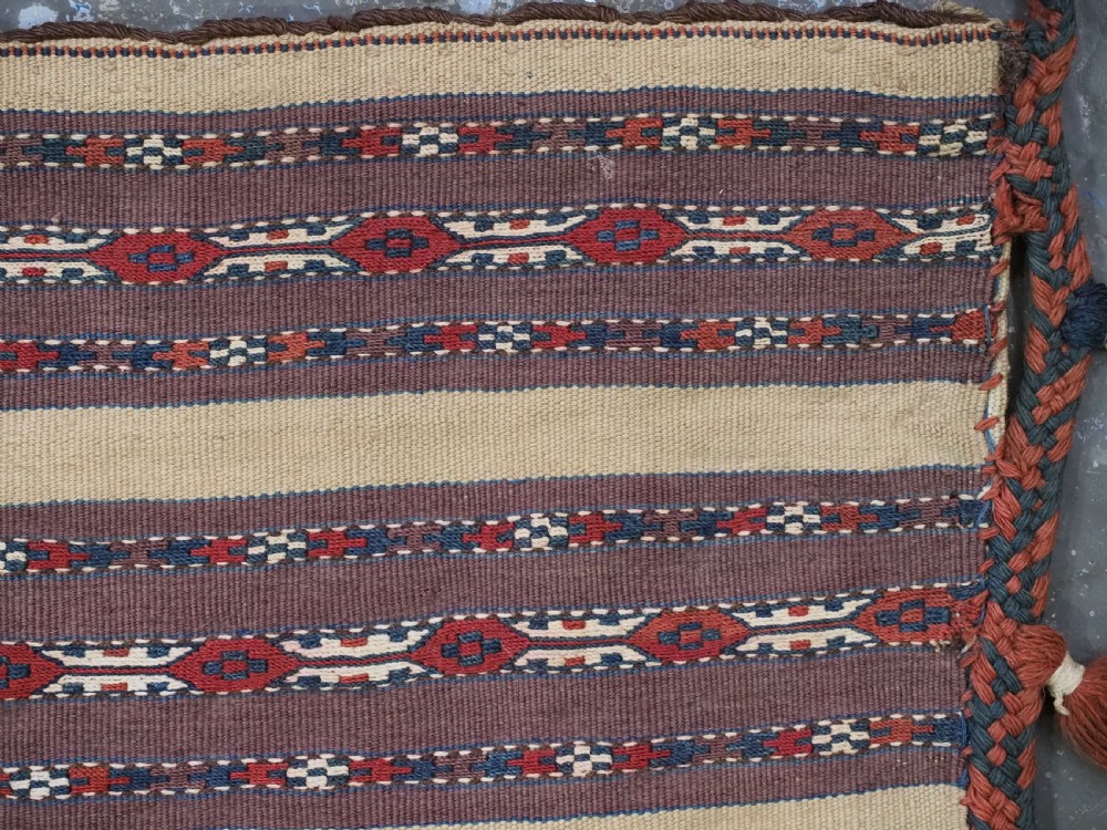 An antique Turkmen flatweave panel with horizontal cream, dark brown, and terracotta geometric bands decorated with side tassels and fringing. View VII