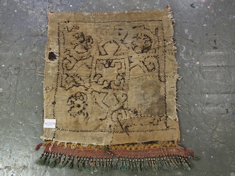An antique square Kirghiz felt panel featuring central scroll embroidery in red, yellow, and white, framed by a red border with applied tasselled fringe at the bottom edge. View VII