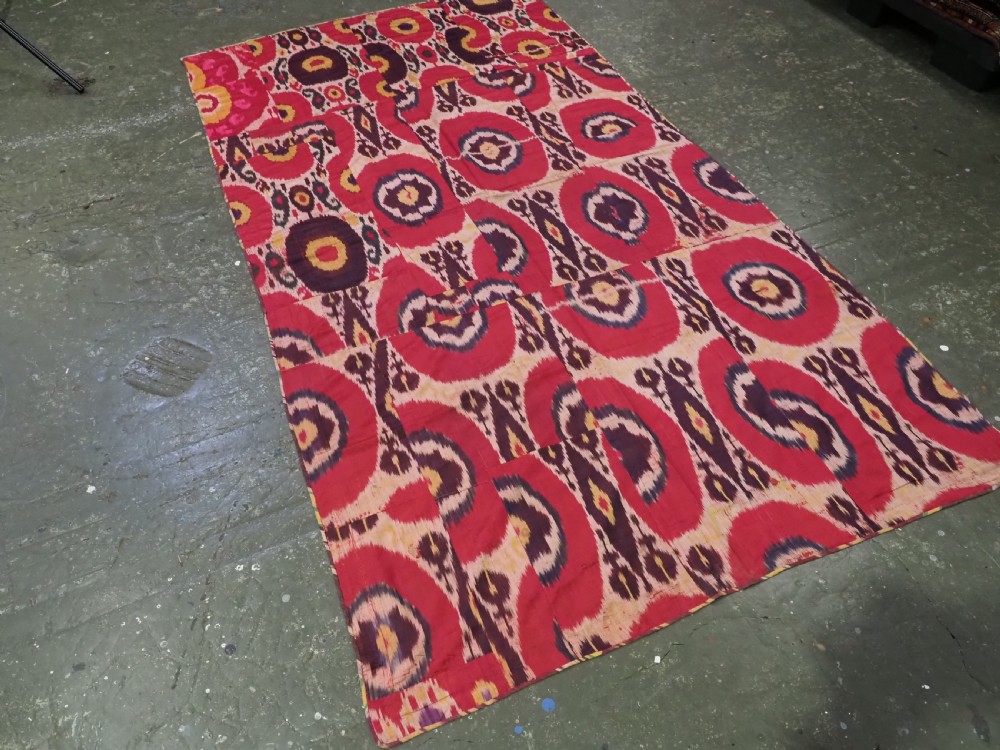 A vertical handwoven silk ikat textile panel featuring bold crimson, yellow, and deep purple circular geometric patterns on an off-white background. View II
