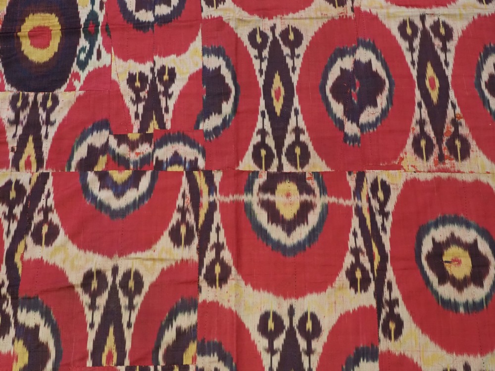 A vertical handwoven silk ikat textile panel featuring bold crimson, yellow, and deep purple circular geometric patterns on an off-white background. View VIII