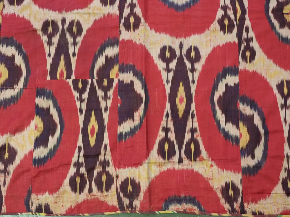 A vertical handwoven silk ikat textile panel featuring bold crimson, yellow, and deep purple circular geometric patterns on an off-white background. View IX