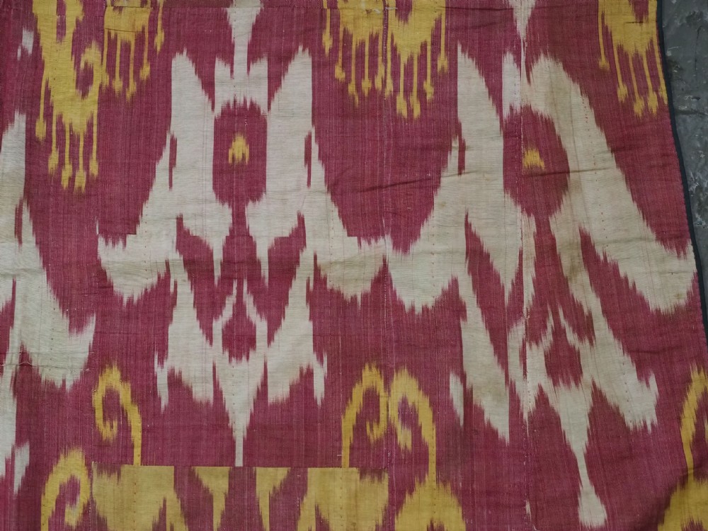 An antique Uzbek silk adras ikat panel featuring bold floral and geometric motifs in crimson red, mustard yellow, and cream. View IX