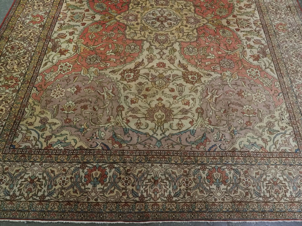 An antique hand-knotted Tabriz carpet featuring a central floral medallion, ornate spandrels, and a multi-tiered border in terracotta, cream, and soft pastel shades. View V
