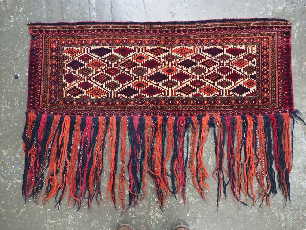 An antique Tekke Turkmen torba face featuring a geometric curled leaf diamond pattern on an ivory field with a thick wool fringe. View II