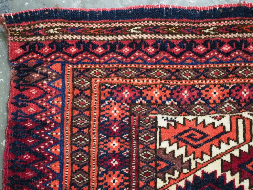 An antique Tekke Turkmen torba face featuring a geometric curled leaf diamond pattern on an ivory field with a thick wool fringe. View IX