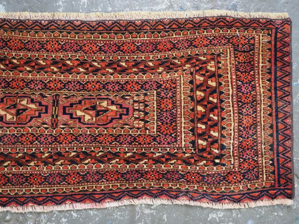 A horizontal hand-knotted wool Tekke Turkmen torba face featuring four central chuval guls enclosed by geometric borders in deep red, navy, and ivory. View III