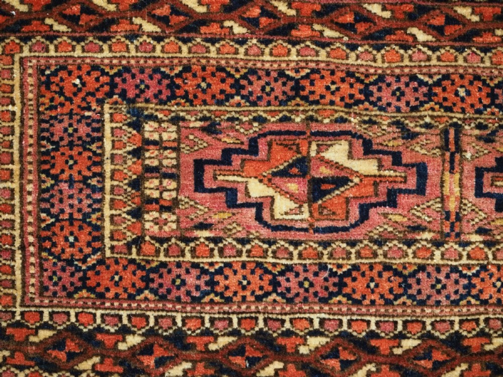 A horizontal hand-knotted wool Tekke Turkmen torba face featuring four central chuval guls enclosed by geometric borders in deep red, navy, and ivory. View VI