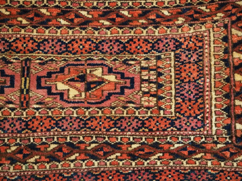 A horizontal hand-knotted wool Tekke Turkmen torba face featuring four central chuval guls enclosed by geometric borders in deep red, navy, and ivory. View VIII