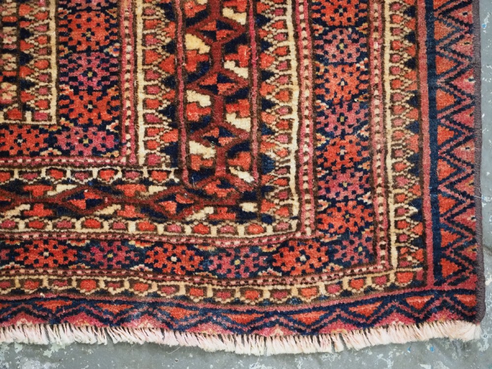 A horizontal hand-knotted wool Tekke Turkmen torba face featuring four central chuval guls enclosed by geometric borders in deep red, navy, and ivory. View X