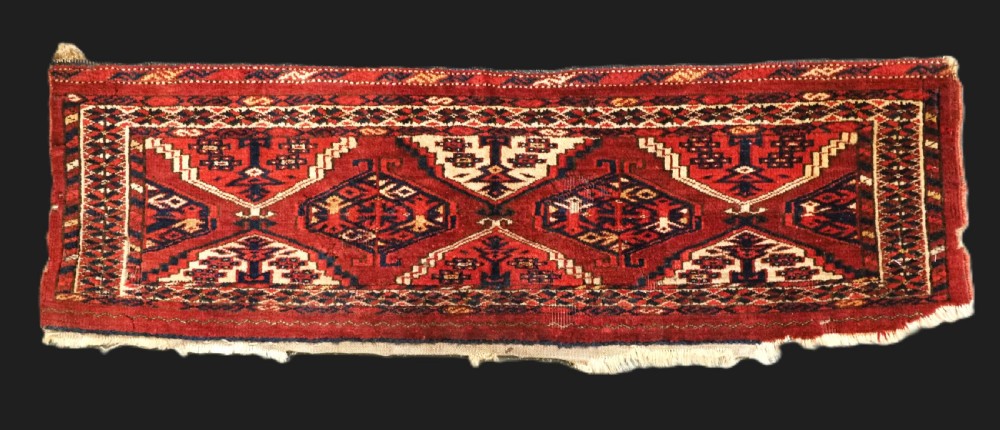 An antique horizontal hand-woven Ersari Turkmen wool torba featuring repeating geometric diamond guls in red, white, and dark blue tones.