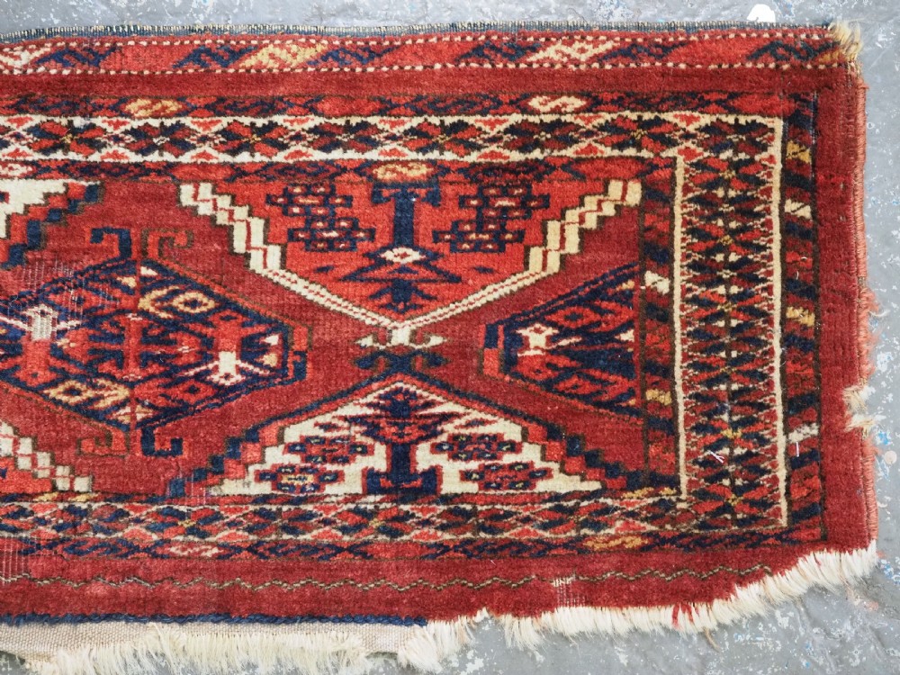 An antique horizontal hand-woven Ersari Turkmen wool torba featuring repeating geometric diamond guls in red, white, and dark blue tones. View VI