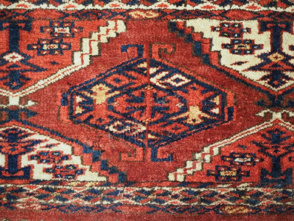 An antique horizontal hand-woven Ersari Turkmen wool torba featuring repeating geometric diamond guls in red, white, and dark blue tones. View VIII