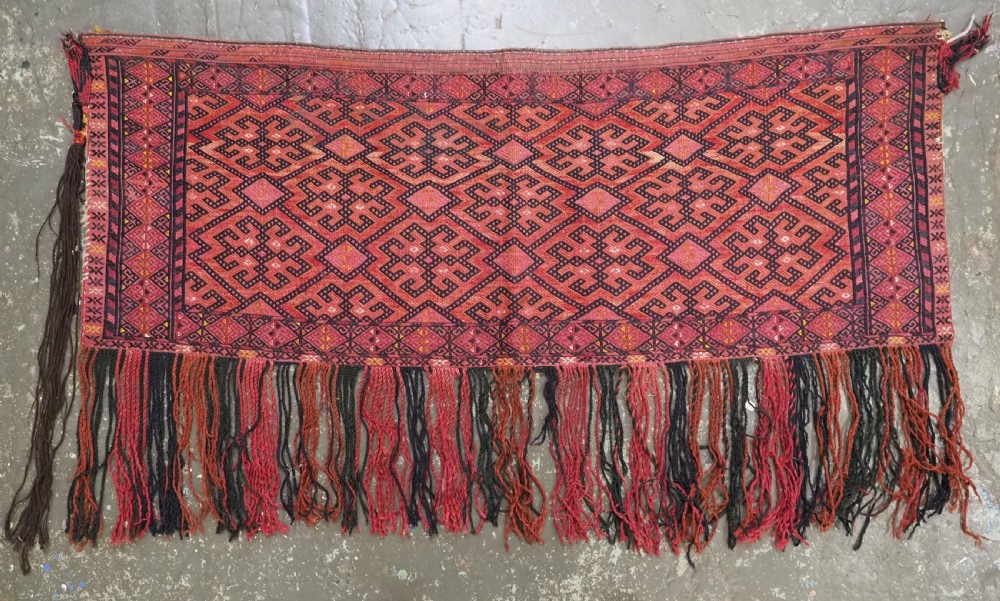An elongated rectangular Turkmen Ersari torba featuring geometric diamond embroidery in red and dark tones with long fringed tassels along the bottom. View II