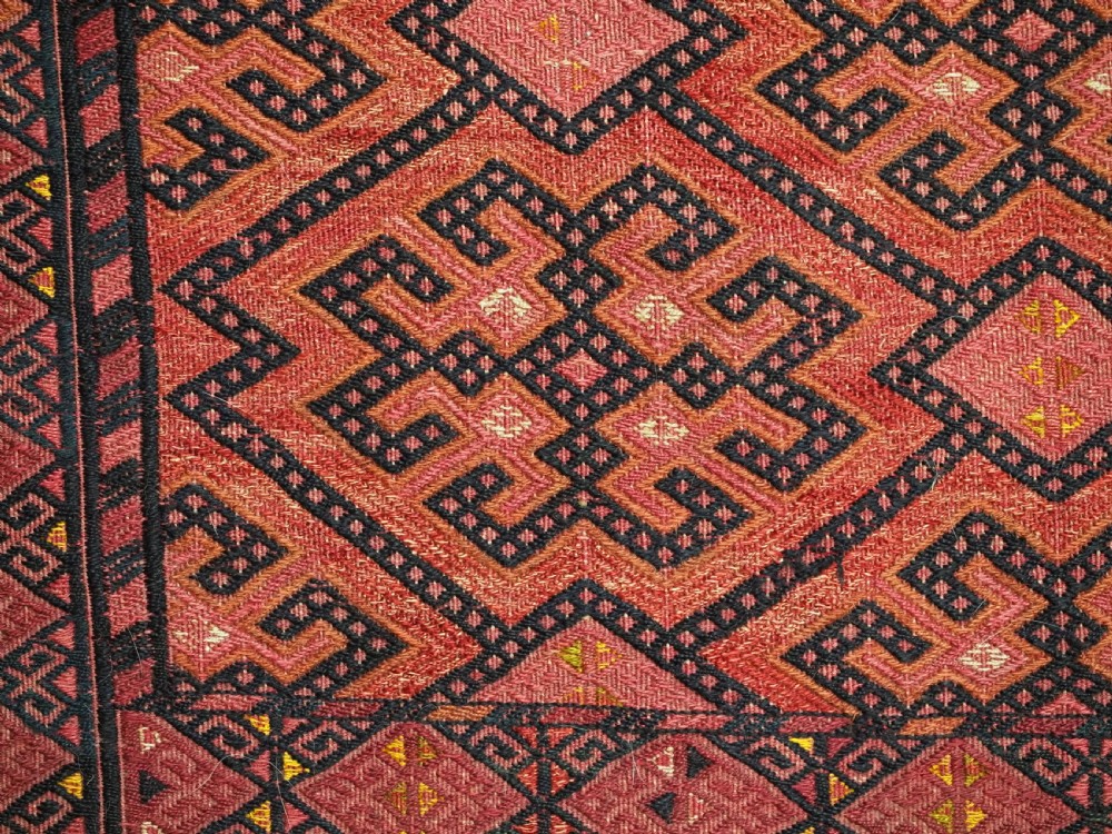 An elongated rectangular Turkmen Ersari torba featuring geometric diamond embroidery in red and dark tones with long fringed tassels along the bottom. View IX