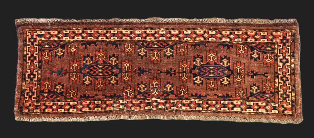 A horizontal rectangular antique wool torba bag face featuring central diamond-shaped Kepse gul motifs in deep red, indigo blue, and ivory framed by a geometric border.