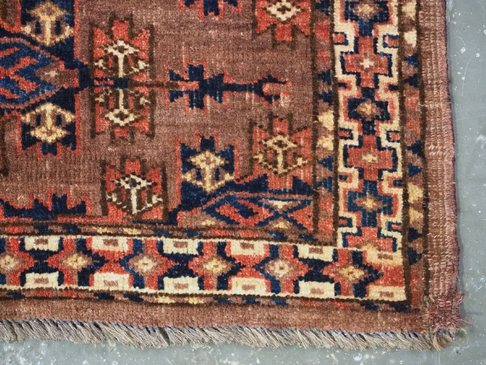 A horizontal rectangular antique wool torba bag face featuring central diamond-shaped Kepse gul motifs in deep red, indigo blue, and ivory framed by a geometric border. View VII